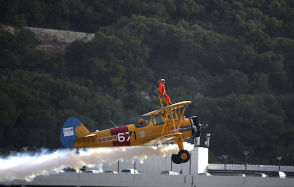 Tom Lackey, un acróbata británico de 94 años, desafió este sábado los límites de la naturaleza con una nueva hazaña que le ha permitido volar con el cuerpo atado a un avión biplano "Boeing Stearman" alrededor del peñón de Gibraltar. Foto: AFP