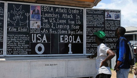 Transeúntes leen titulares de del periódico mural Daily Talk escritos en una pizarra: "Ébola 1 : EU 0", en Monrovia. Foto: Reuters