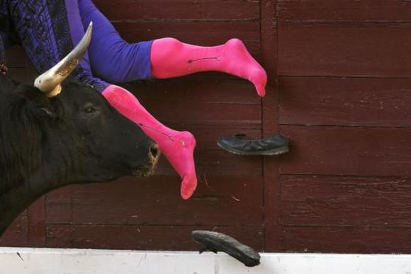 El banderillero Vicente Cabanes pierde su calzado tras ser embestido por un toro de la ganadería Guardiola Fantoni, durante una corrida en la plaza de Las Ventas, en Madrid, España, el 10 de agosto de 2014. AP Phot