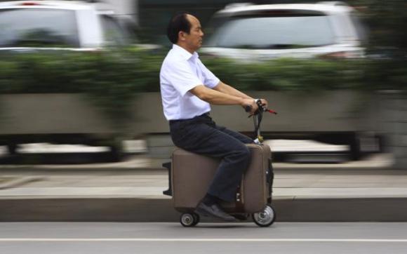 He Liang maneja su moto-maleta casera en una calle en la provincia china de Hunan este 28 de mayo de 2014. Liang ha pasado 10 años modificando esta valija para convertirla en un vehículo motor que puede alcanzar lo
