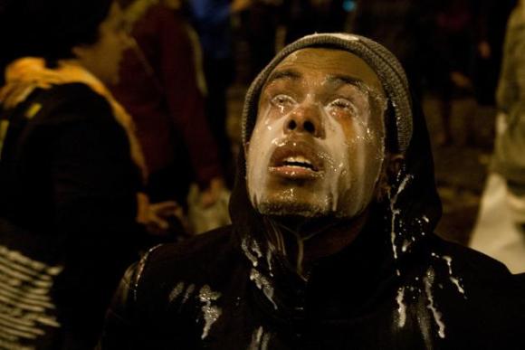 Un manifestante vierte leche sobre sus ojos después de haber sido rociado con gas lacrimógeno por la policía de Seattle el lunes 24 de noviembre de 2014. Los manifestantes salieron a las calles de Ferguson, Missour
