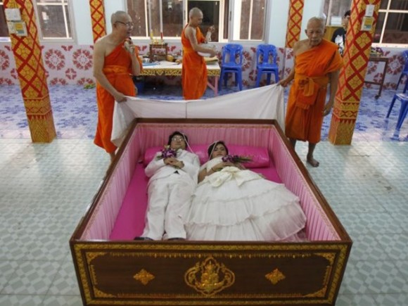 Tanapatpurin Samangnitit y su novia Sunantaluk Kongkoon están dentro de un ataúd durante una ceremonia de boda en Wat Takien templo en las afueras de Bangkok, durante el 14 de febrero. / Foto: elmeme.me