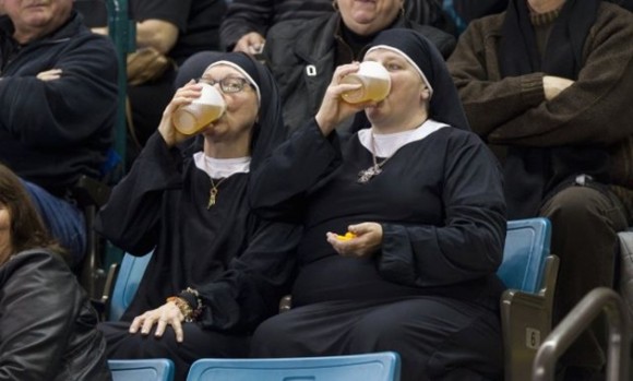 Canadá: dos mujeres vestidas de monjas beben cerveza mientras observan un partido de curling / Foto: elmeme.me