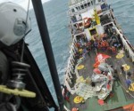 Momento en el que suben la cola del avión al barco de rescate indonesio. Foto: EFE