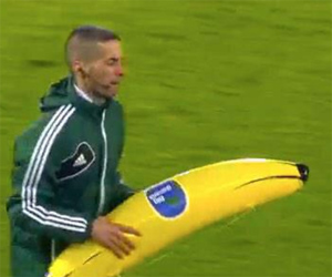 El cuarto árbitro retira el plátano hinchable lanzado por los seguidores del Feyenoord a Gervinho.