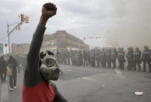 Rozando la medianoche, buena parte de Baltimore comenzaba ya a parecer una ciudad sitiada por la policía -más de 5.000 agentes han sido desplegados- que se hacía fuerte en las calles y avenidas principales. Foto: Boston Globe