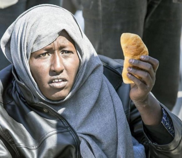 Una inmigrante enseña un trozo de pan en Calabria. Foto: EFE 