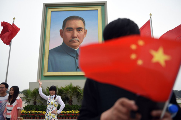Asistentes a los actos del Primero de Mayo en la plaza de Tiananmen de Pekín se fotografían con el retrato de Sun Yat-sen, considerado el padre fundador de la China moderna.