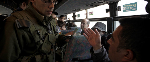 Un soldado israelí pide la documentación a un palestino en un control | REUTERS