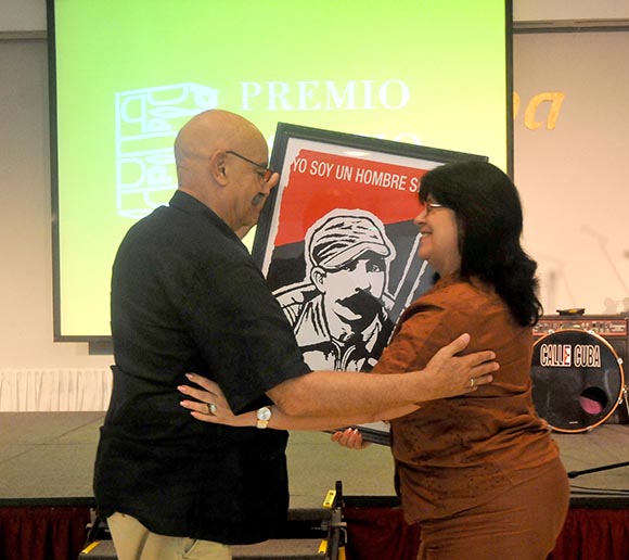 El presidente de la Upec, Antonio Moltó, hizo entrega de un reconocimiento a la Asociación Cubana de Comunicadores Sociales. Foto: Ismael Batista / Granma