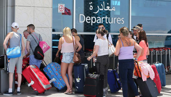 Un grupo de turistas británicos se dirigen con sus maletas a la zona de salidas del aeropuerto más próximo a Susa. Foto: EFE