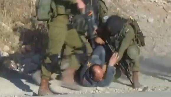soldados israelíes golpean a palestino