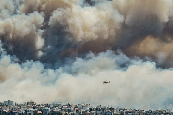 Labores de extinción del incendio que se ha producido en el monte Imitós de Atenas y que ha obligado a evacuar cinco pueblos y dos campamentos de verano. Foto: AFP