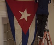 Momento en que un trabajador de la Embajada colocaba la bandera en el segundo piso del edificio, frente al salón donde celebrará la ceremonia oficial de este lunes. Foto: Ismael Francisco/ Cubadebate