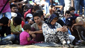 Inmigrantes esperan en una estación de trenes cerca de la ciudad de Gevgelija (Macedonia)