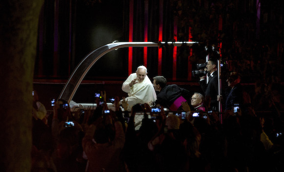 Pope Francis waves to the crowd as he passes along Benjamin Franklin Parkway, Saturday, Sept. 26, 2015, in Philadelphia. The pontiff attended a music-and-prayer festival there Saturday night to close out the World Meeting of Families, a Vatican-sponsored conference of more than 18,000 people from around the world. (AP Photo/Alessandra Tarantino)