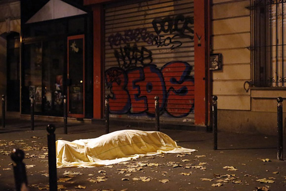 13 de noviembre, una víctima de ataques terroristas yace muerto en las afueras del teatro Bataclan en París. Foto: Jerome Delay/AP.