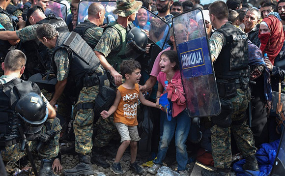 21 de agosto, niños lloran mientras migrantes y refugiados que intentan cruzar a Macedonia por la frontera con Grecia se enfrentan a la policía. Foto: Georgi Licovski/EPA.