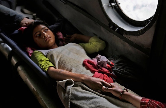 27 de abril, una niña nepalí dañada por el terremoto sostiene la mano de su madre dentro de un helicóptero de la fuerza india. Foto: Altaf Qadri/AP.