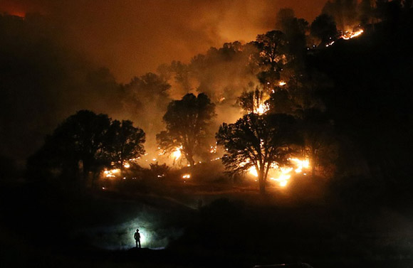 3 de agosto, la silueta de un bombero es visible por la lámpara de su cabeza en la batalla contra el llamdo Fuego de Rocky cerca de Crearlake, California. Foto: Justin Sullivan/Getty Images.