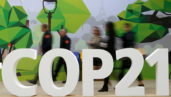 Delegados caminan junto al logo de la COP21 en la zona parisina de Le Bourget (Foto: Stephane Mahe/Reuters)
