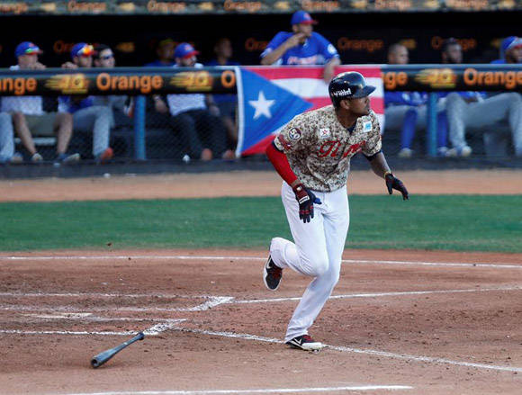 El jugador de Los Tigres de Aragua José Alberto Martínez corre a primera base después de batear ante Los Cangrejeros de Santurce. Foto: EFE.
