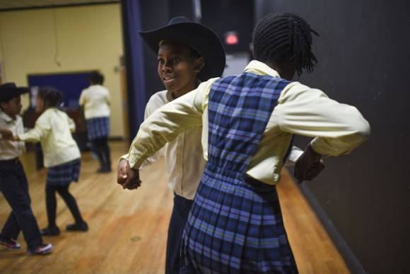 Jackson Adams, de 13 años, baila con Lindsay Smith, de 12, durante uno de muchos ensayos que los estudiantes han realizado antes de su viaje. Foto: Michael Robinson Chavez / The Washington Post