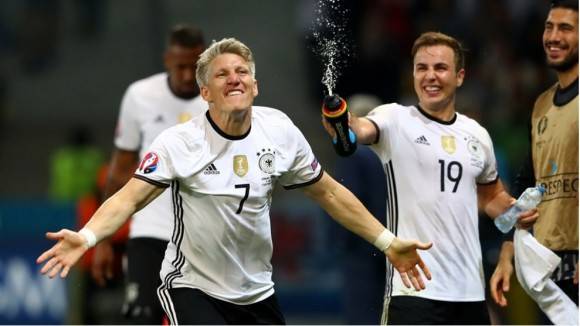 Bastien Schweinsteger es mojado por Mario Goetze en la celebración del segundo gol teutón. Photo by Alexander Hassenstein Getty Images