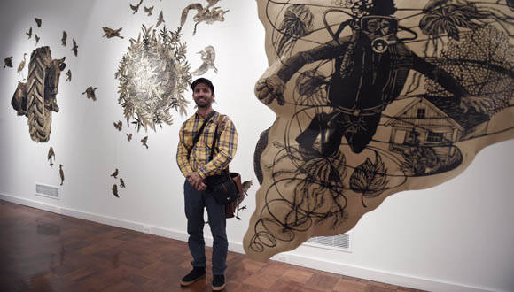 El Artista Osmeivy Ortega frente a su obra. Foto: EFE.
