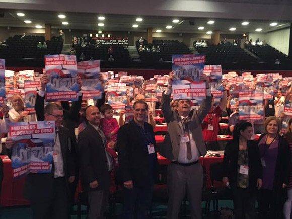 Gerardo y René levantan sus pancartas en el acto de la Unión de Delegados en el Reino Unido. Foto: Cuba Solidarity Campaing/ Facebook.