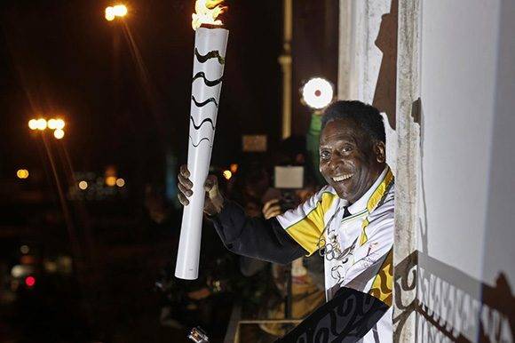 Pelé sostiene la antorcha olímpica. El astro del fútbol no estará en la inauguración por problemas de salud. Foto: AFP PHOTO/ Andre Luiz Mello.