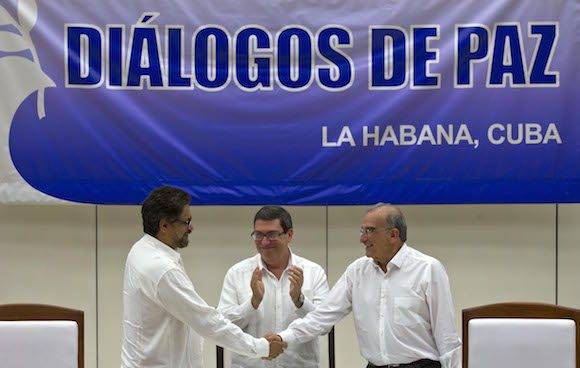 Humberto de la Calle, derecha, estrecha la mano Ivan Marquez, ante los aplausos del Canciller cubano Bruno Rodriguez . Foto: Ramon Espinosa/ AP