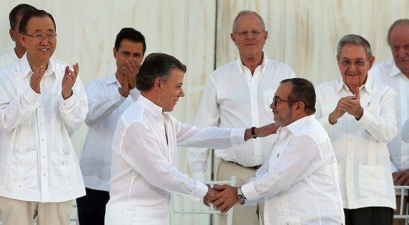 El Presidente Juan Manuel Santos y Rodrigo Londoño, lider de las FARC, firman el acuerdo de paz en Cartagena de India. Foto: Fernando Vergara/ AP