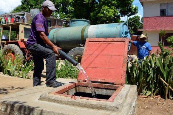 Tractor con tanque llena una cisterna, para asegurar el abasto de agua potable a la población, ante la llegada del huracán Matthew, en la ciudad de Bayamo, provincia de Granma, Cuba, el 2 de octubre de 2016. Foto: Armando Ernesto Contreras Tamayo / ACN 