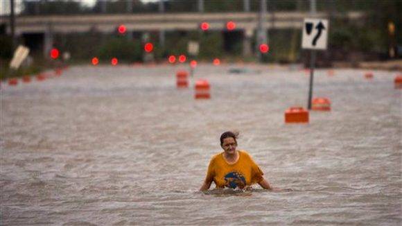 Mujer camina entre las aguas en Georgia EE UU tras paso de huracán Matthew. Foto: AP