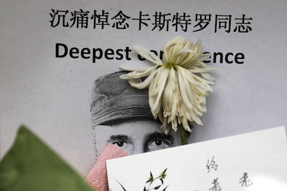 A chrysanthemum lay on an image of the late Cuban President Fidel Castro outside the Cuban embassy in Beijing, Tuesday, Nov. 29, 2016. After his band of bearded rebels won power in 1959, Castro embarked on a victory tour delivering speeches to cheering crowds stretching from the eastern Cuban city of Santiago to Havana. Starting Wednesday, his ashes will retrace that journey in a solemn procession to his final resting spot. (AP Photo/Andy Wong)