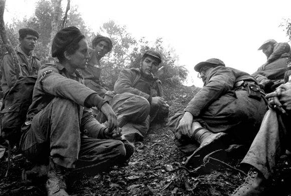 Camilo Cienfuegos, Fidel Castro y Che Guevara, de derecha a izquierda, escuchan las informaciones que les da Maracaibo, un explorador que acababa de regresar de las líneas enemigas durante el combate de Pino del Agua, en septiembre de 1957. Foto: Enrique Meneses. 