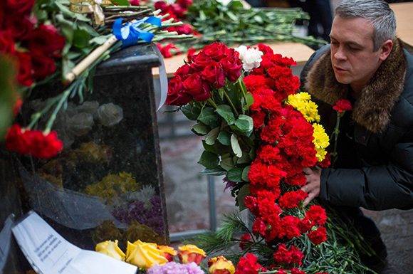 Un hombre deposita flores en al sede del coro del Ejército Rojo en Moscú. Foto: AFP.