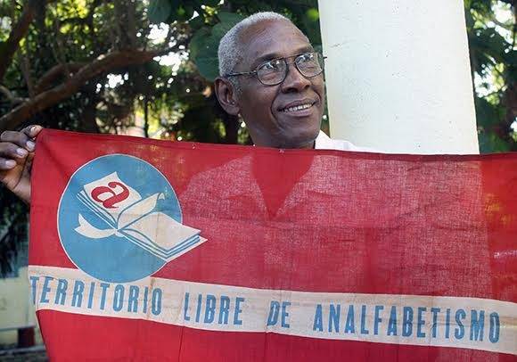Sergio Ballester sostiene la bandera que fue izada al convertirse Cuba en territorio libre de analfabetismo. Foto: José Raúl Concepción Llanes/ Cubadebate.