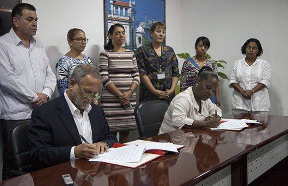 Scott Gilbert, presidente de la empresa estadounidense Coabana Trading LLC e Isabel O'Reilly, directora de CubaExport, firman el acuerdo que permite la exportación de carbón vegetal cubano a los Estados Unidos. Foto: Ladyrene Pérez/ Cubadebate.