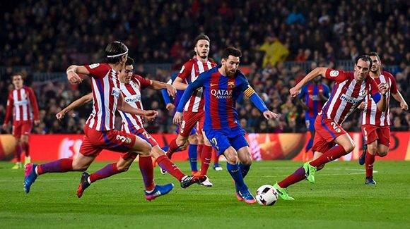 Messi intenta marcharse rodeado de defensas del Atlético. Foto: AFP.