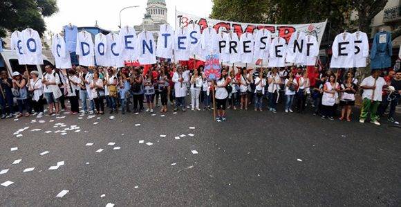 Maestros de escuelas públicas en huelga sostienen uniformes que forman las palabras "Maestros presentes" fuera del Congreso durante una protesta en Buenos Aires, Argentina. Foto: REUTERS/ Marcos Brindicci