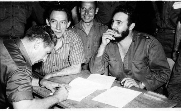 Fidel luego de firmar la Ley de Reforma Agraria le pasa el histórico documento a Luis Orlando Rodríguez, quien lo està  rubricando. Junto al Comandante en Jefe aparecen el médico Comandante Julio Martínez Paez, ministro de Salubridad y el Ministro de Trabajo, Manuel Fernández.