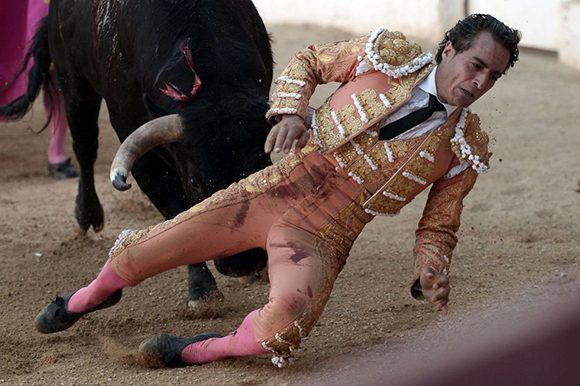 Fandiño cae al suelo tras tropezar con el capote y el toro le enviste. Foto: Iroz Gaizka/ AFP.
