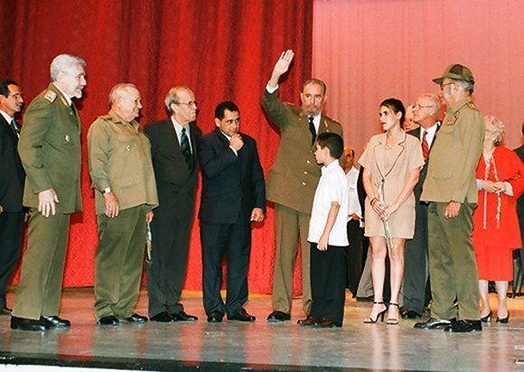 Fidel saluda a los participantes en el acto por el 45 aniversario de la Revolución Cubana. Junto a él, Elián González y su familia, así como otros héroes y dirigentes. Foto:Estudios Revolución. 