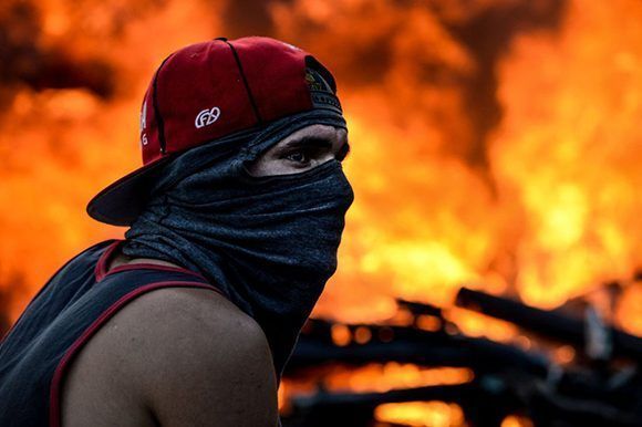 Un manifestante encapuchado durante las agresivas protestas de esta semana en Venezuela. Foto: AFP.