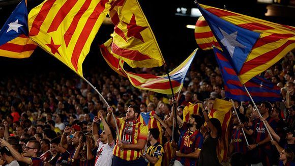 Aficionados del FC Barcelona ondean banderas catalanas para pedir la independencia durante un partido de fútbol en el Camp Nou. Foto: Atlas.