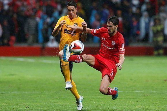 Fernando Torres y Santiago García disputan por el balón durante el empate sin goles entre el Atlético de Madrid y el Toluca. Foto: Reuters.