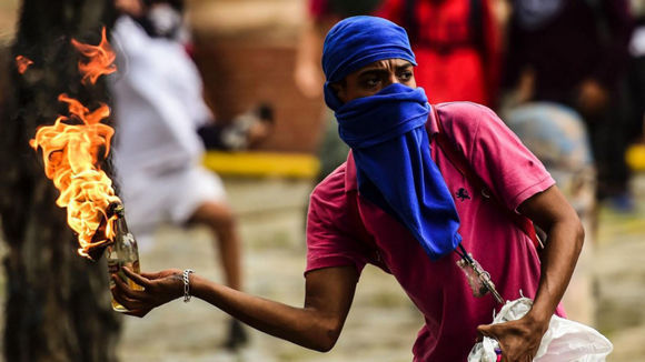 Un opositor “pacífico” lanza un cóctel molotov durante una protesta en Caracas, el 20 de julio de 2017. Foto: Ronaldo Schemidt / AFP/Getty Images.