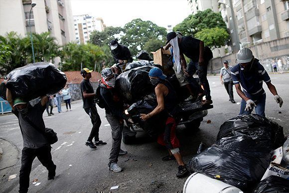 Un grupo de manifestantes construye una barricada durante una protesta contra el Gobierno de Nicolás Maduro en Caracas, Venezuela, el 26 de julio de 2017. Foto: Ueslei Marcelino/ Reuters.